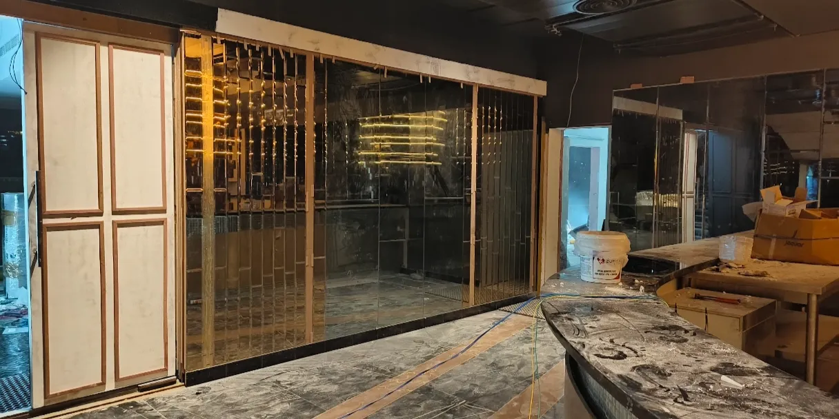 Decorative tinted glass room divider with a sleek finish, offering privacy and a sophisticated interior design element at Fashion Elite.