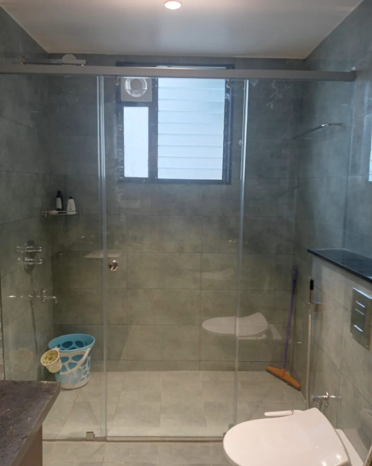 Modern frameless sliding glass shower door with minimalist chrome hardware and a clear tempered glass enclosure for a luxury bathroom.