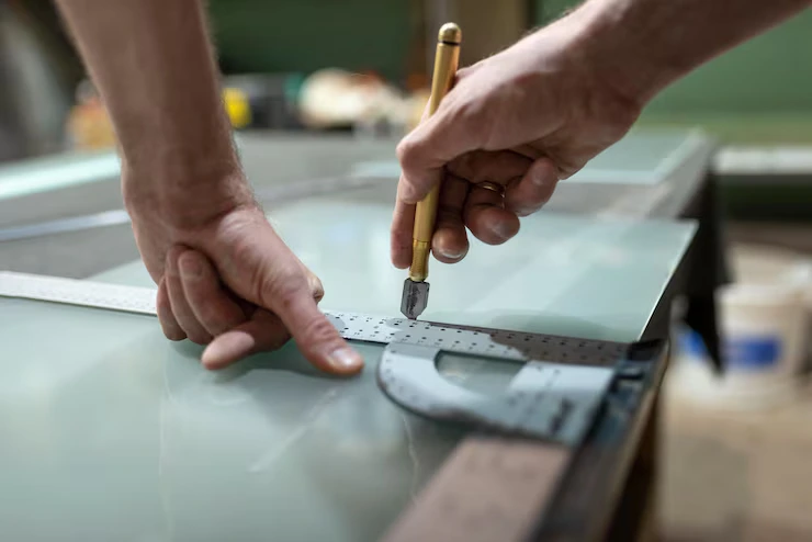 Glass cutting and precise measurement work by professional glass technician