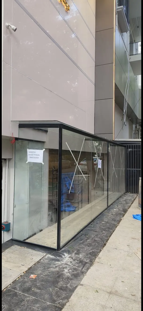 Modern minimalist office storefront featuring a large glass front door with sleek black metal framing and a clean, professional entryway.